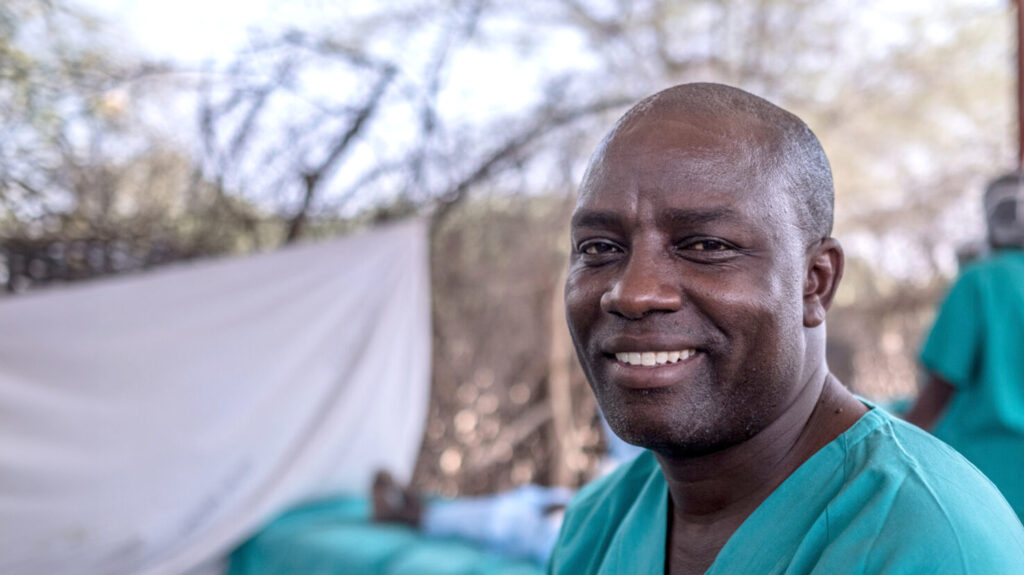 Dr Abony smiles for a photo wearing scrubs.