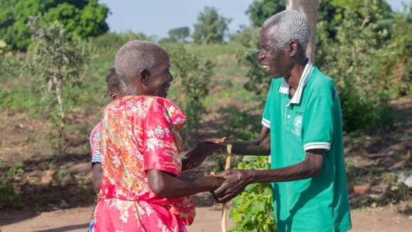 Apolot warmly greets an older man after her cataract operation.