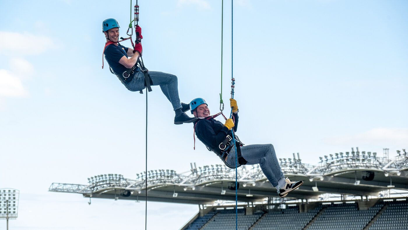 Two men abseil together from the roof of Croke Park in Dublin.