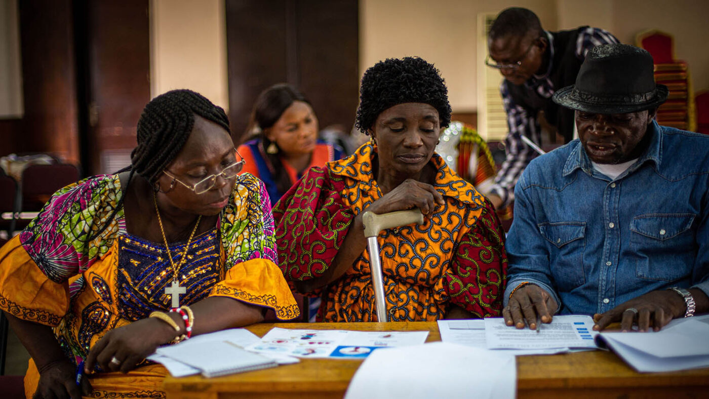 Three people with disabilities at a training session on sexual and reproductive health rights.