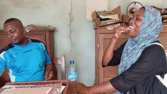 Khadijah swallows medication to protect her from two NTDs.