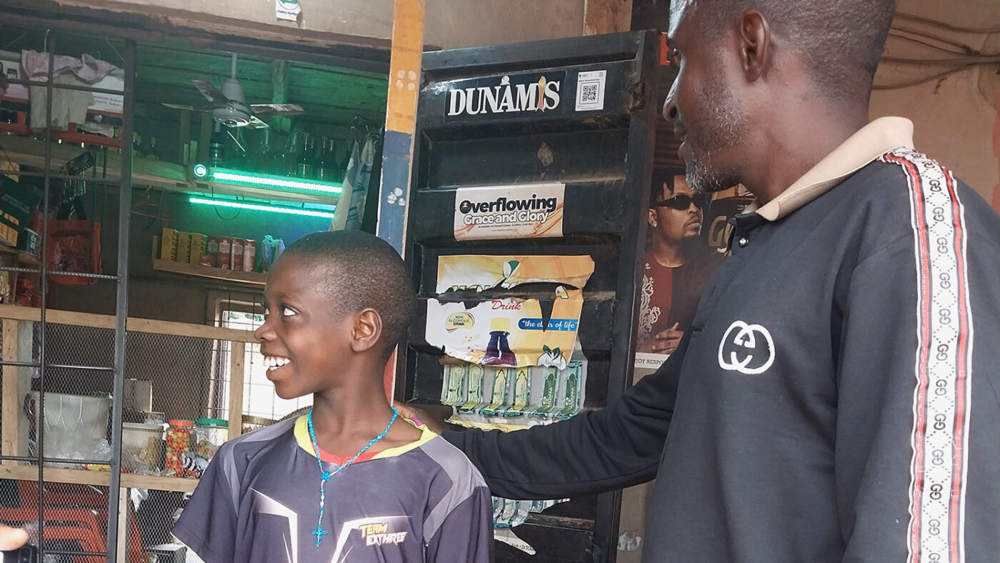 Volunteer community drug distributor Moses measures a child using a dose pole.