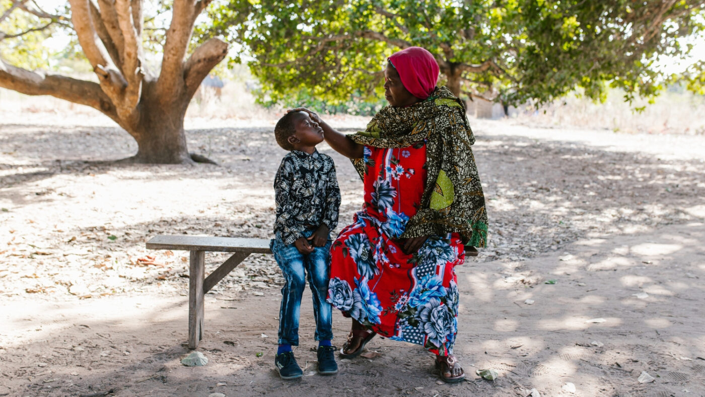 Sophia, Mohamed's grandmother, checks Mohamed's infected eyes.