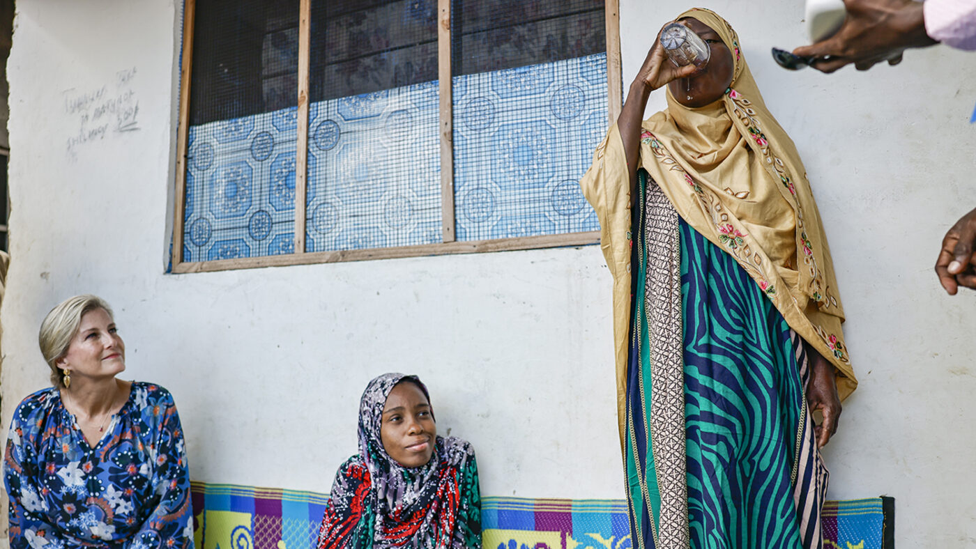 The Duchess of Edinburgh watches Mzowele receiving medication for lymphatic filariasis.
