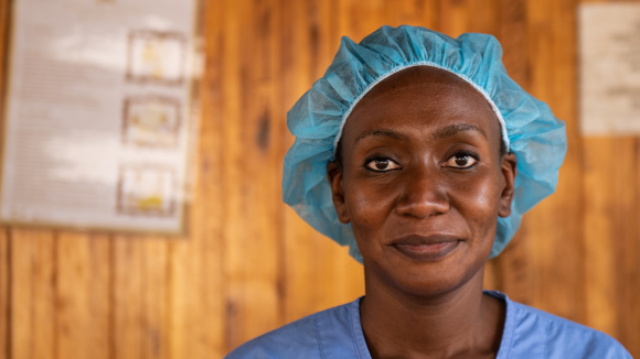 A female doctor smiles at the camera.