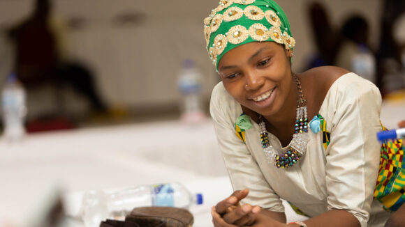 Sadha leans across a table at a political participation workshop.