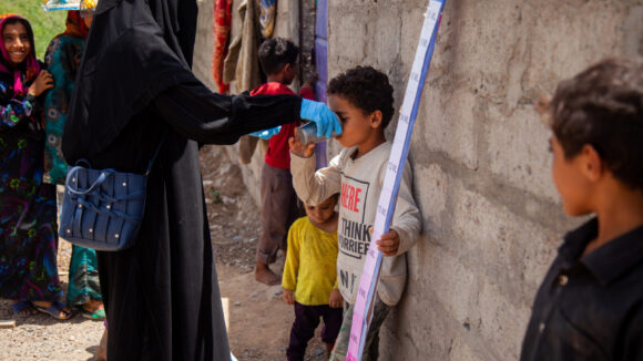A child in Yemen takes an oral treatment for trachoma at a treatment camp.