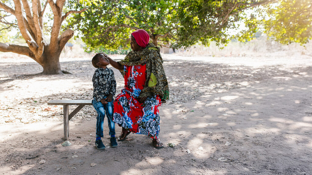 Sophia, Mohamed's grandmother, checks Mohamed's infected eyes.