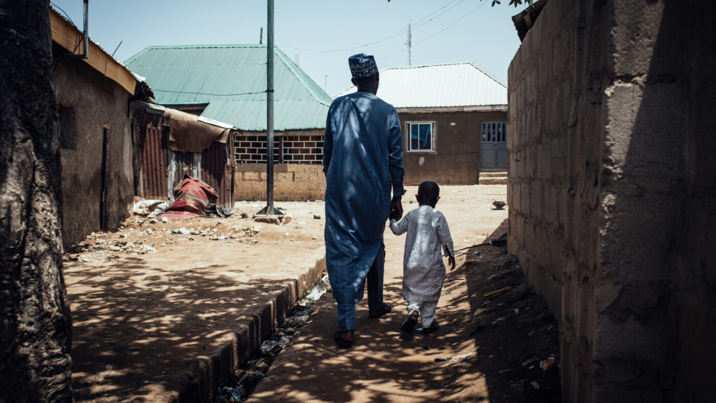 Muhammad and Abubakar walk together through their village.
