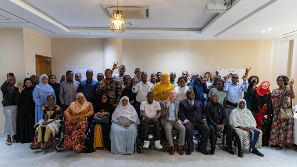 A large group of people pose for a photograph.