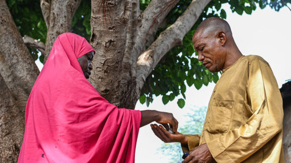 A community volunteer gives a man medication.
