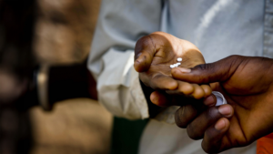A round tablet sits in the palm of a hand.