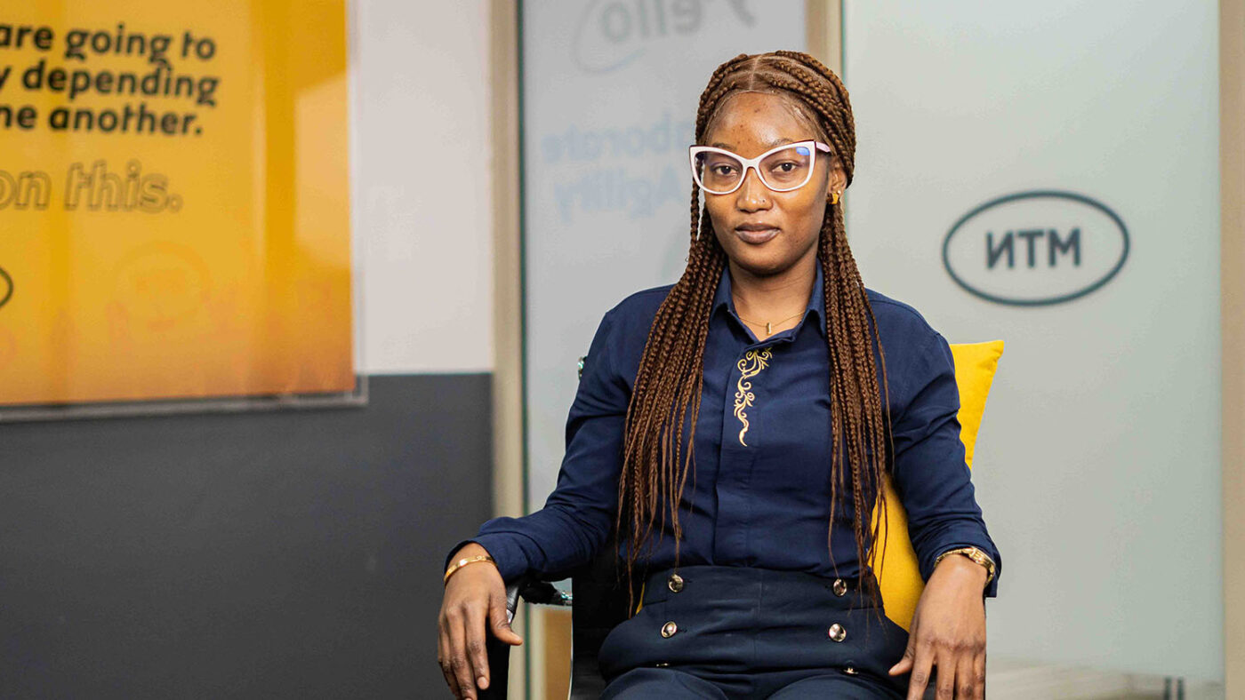 A seated woman who wears spectacles.