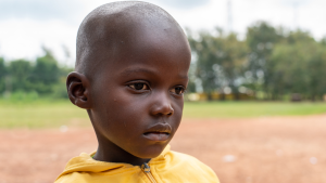 Mehnu stands outside and looks into the distance.
