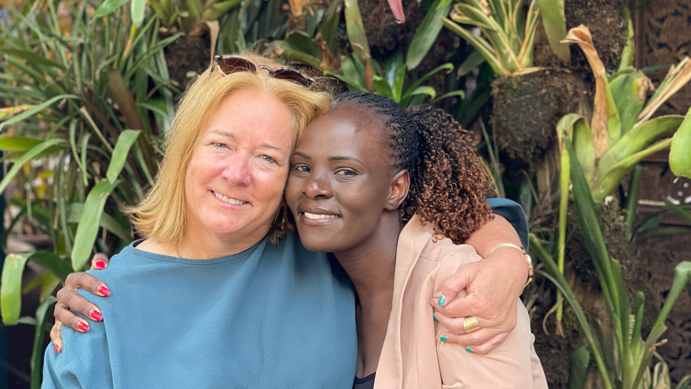 Caroline Harper and Sharon Odongo embrace outside.