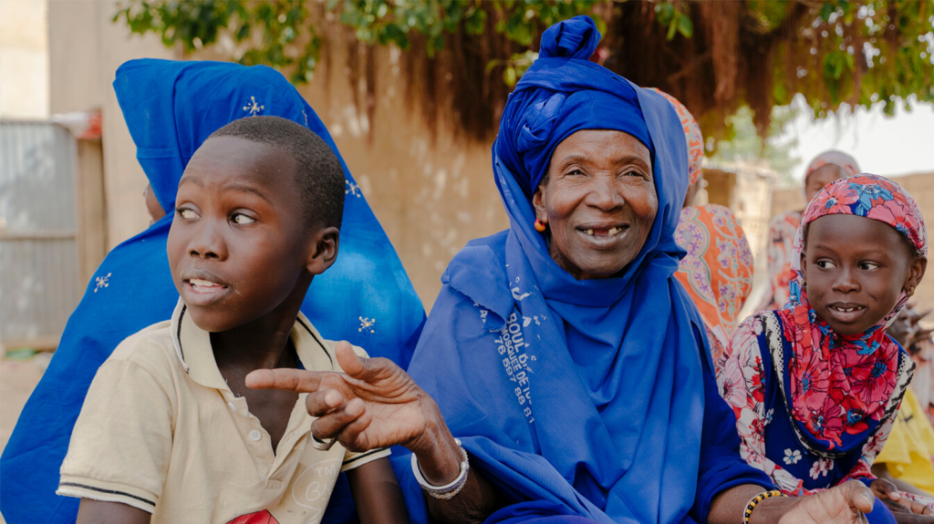 A photo of Nar smiling with her grandchildren