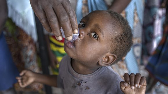 A small child takes medicine for trachoma.