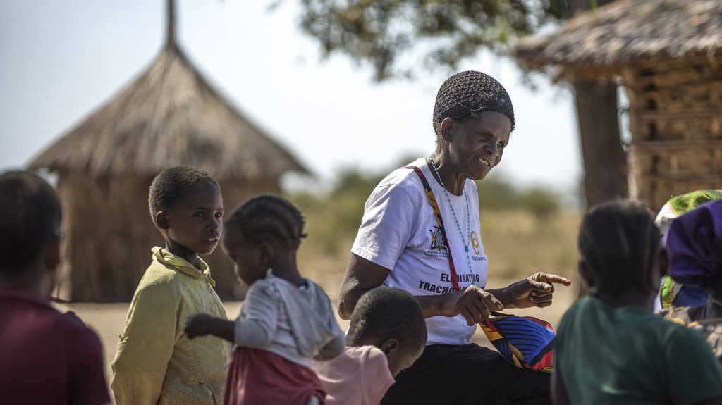 Zita stands outside talking to community members.