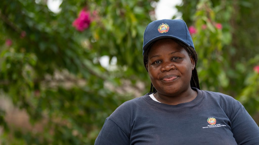 Veronica smiles while wearing a baseball cap with the emblem of Mozambique.